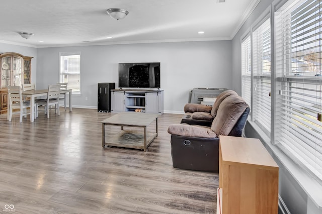 living room with a wealth of natural light, light hardwood / wood-style floors, and ornamental molding