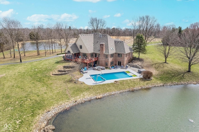 exterior space with a patio, a yard, a water view, and a diving board