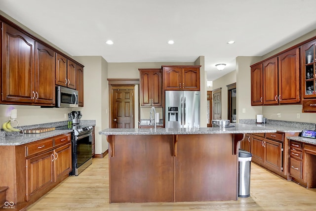 3592 W Smokey Row Rd, Bargersville, IN 46106 - kitchen with stainless steel appliances, light wood-style floors, light stone countertops, a center island, and glass insert cabinets
