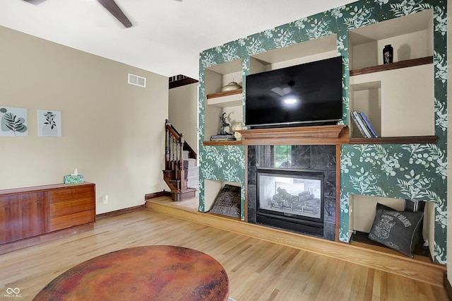 3592 W Smokey Row Rd, Bargersville, IN 46106 - living room with wood finished floors, stairs, a tile fireplace, ceiling fan, and built in features