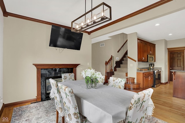 3592 W Smokey Row Rd, Bargersville, IN 46106 - dining area featuring stairway, light wood finished floors, ornamental molding, recessed lighting, and a fireplace