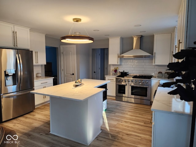 kitchen with white cabinets, wall chimney range hood, and stainless steel appliances