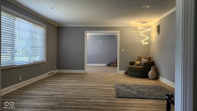 sitting room featuring wood-type flooring and crown molding