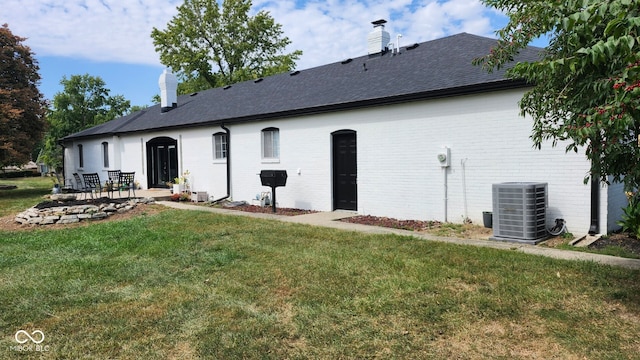 rear view of house featuring a yard, a patio, and cooling unit