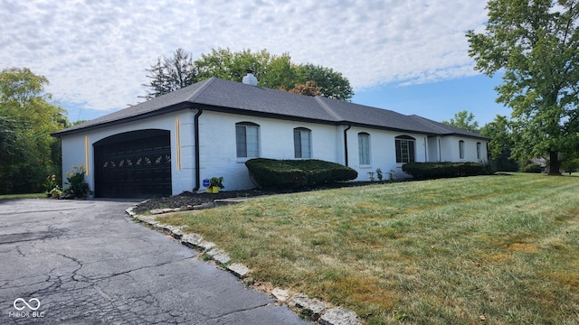 ranch-style home with a garage and a front lawn