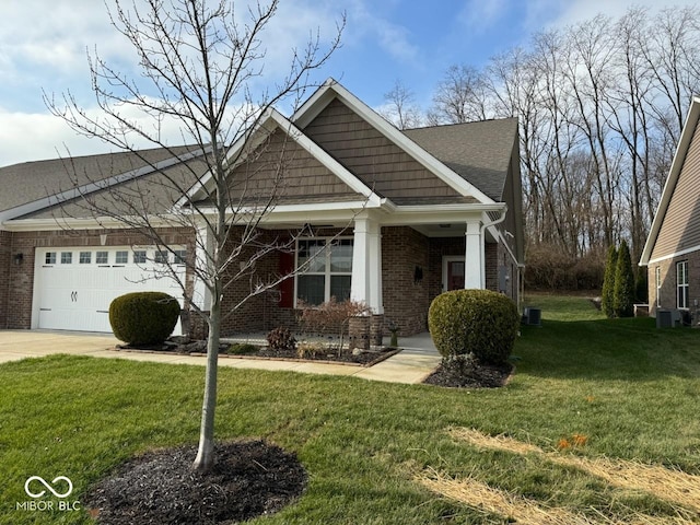 craftsman-style house with central air condition unit, a garage, brick siding, concrete driveway, and a front lawn