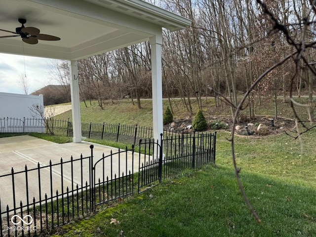 view of yard with ceiling fan and fence