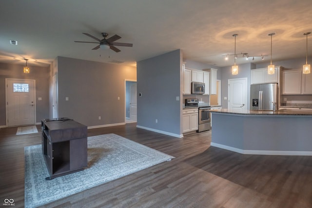 kitchen featuring baseboards, dark wood-style floors, appliances with stainless steel finishes, hanging light fixtures, and white cabinetry