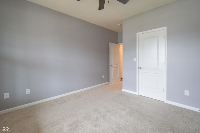 unfurnished bedroom featuring a ceiling fan, light colored carpet, and baseboards