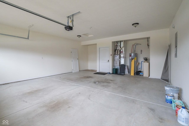 garage featuring water heater, electric panel, and a garage door opener