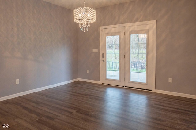 interior space featuring a chandelier, dark wood-type flooring, and baseboards