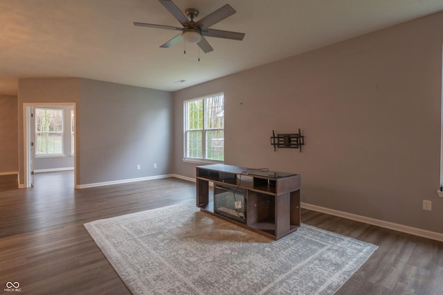 office area with dark wood-style floors, ceiling fan, and baseboards