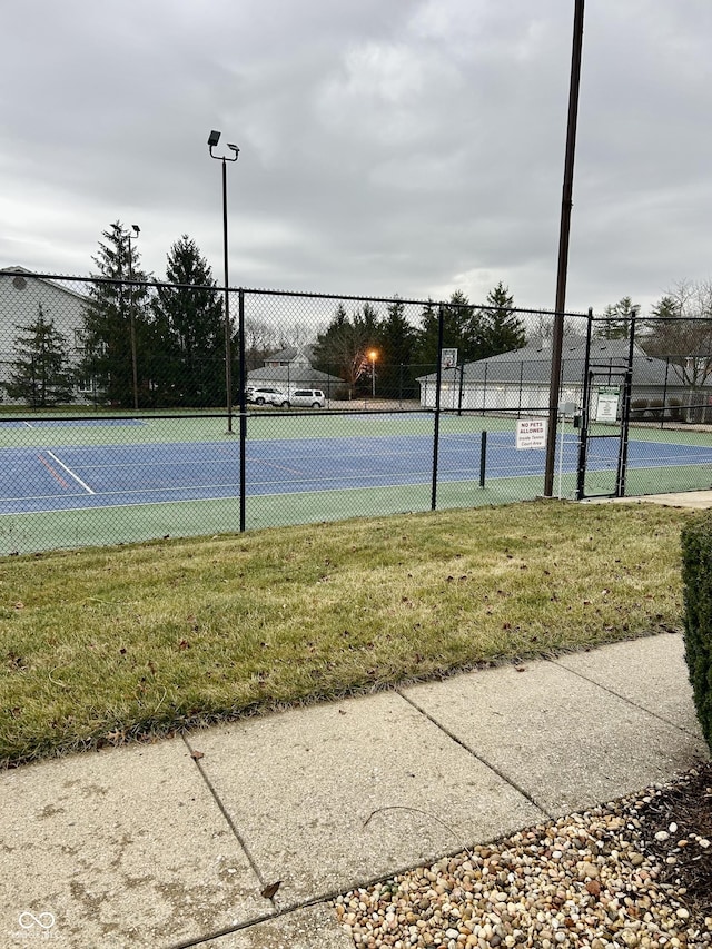 view of sport court with a lawn