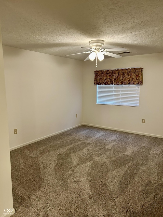 carpeted empty room with ceiling fan and a textured ceiling