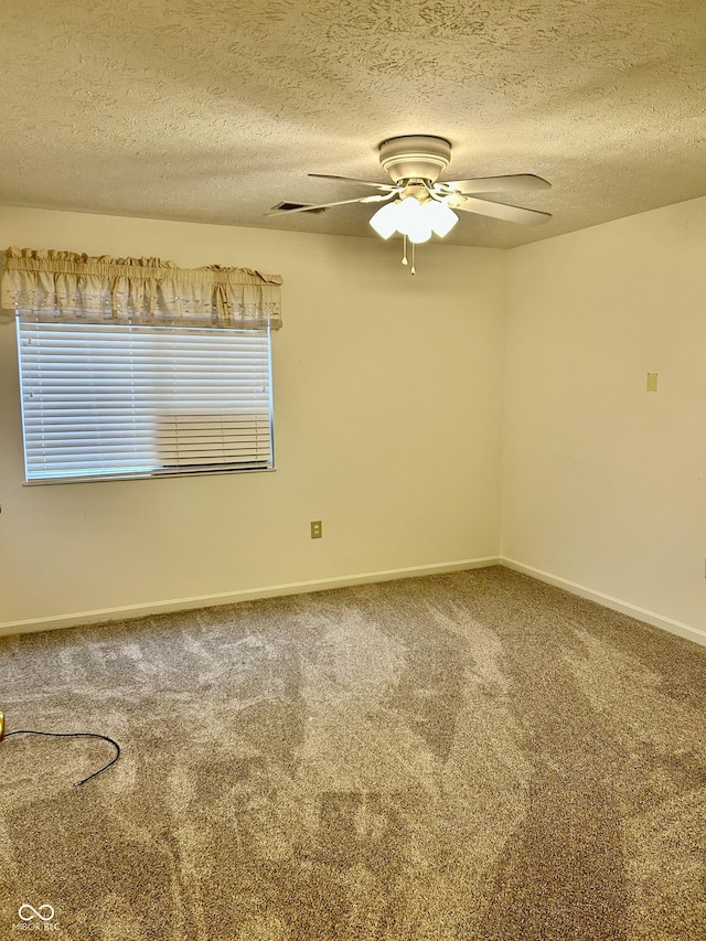 carpeted spare room featuring ceiling fan and a textured ceiling