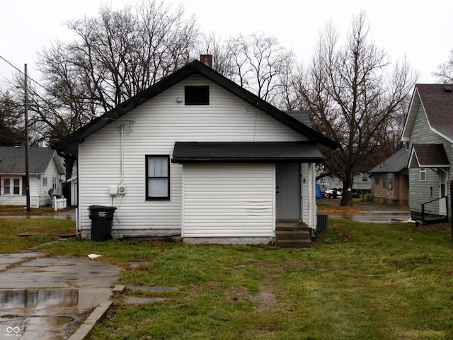 rear view of property featuring a lawn