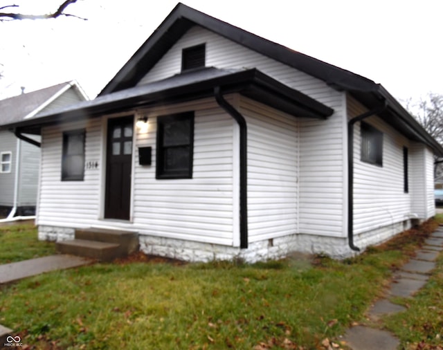 bungalow-style home with a front lawn