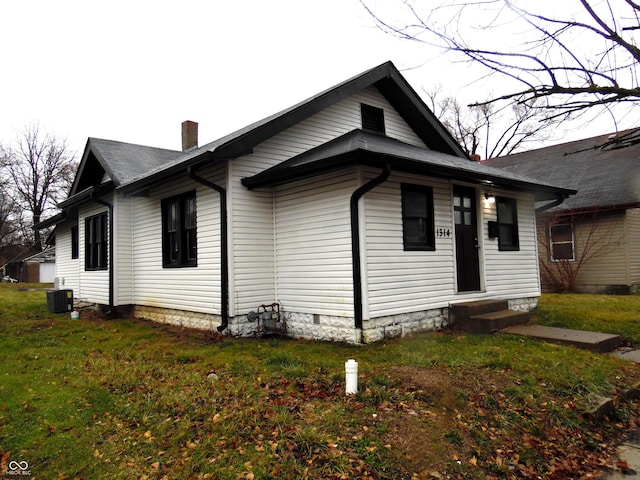 view of front of home with a front yard and central AC unit