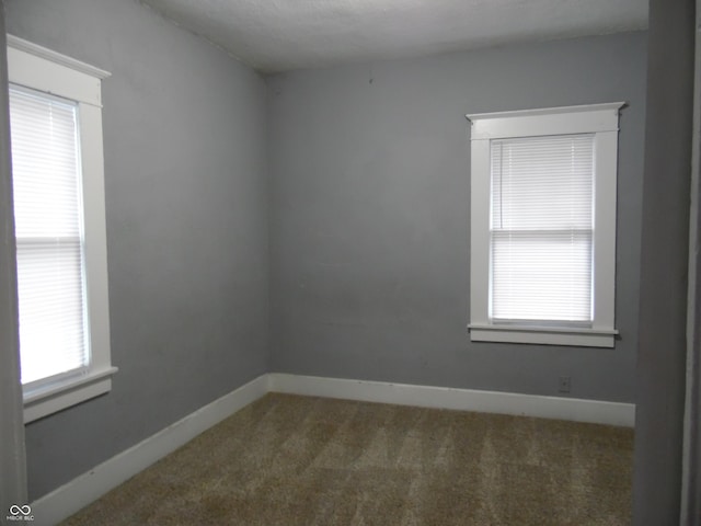 unfurnished room featuring dark carpet