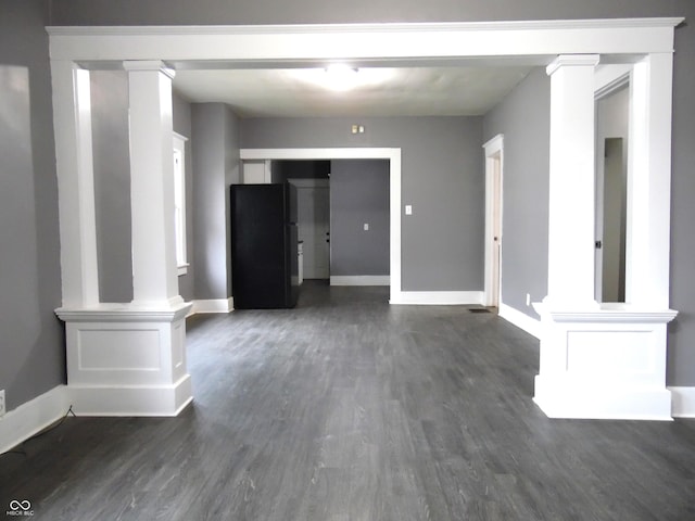 unfurnished living room with dark hardwood / wood-style flooring and decorative columns