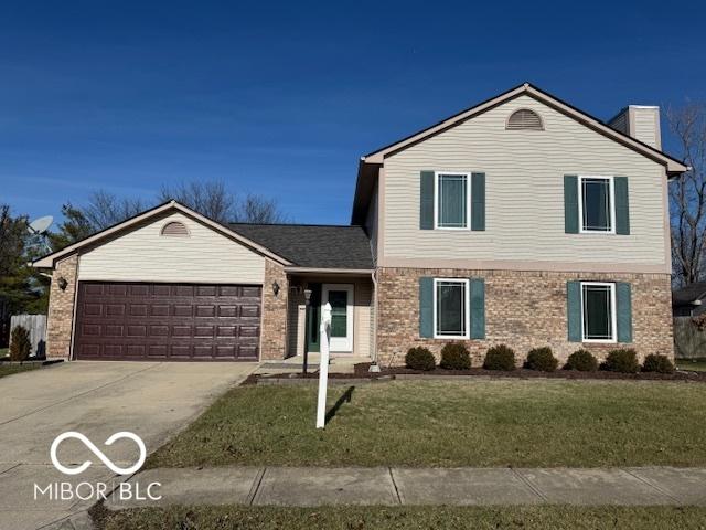 front of property with a front yard and a garage