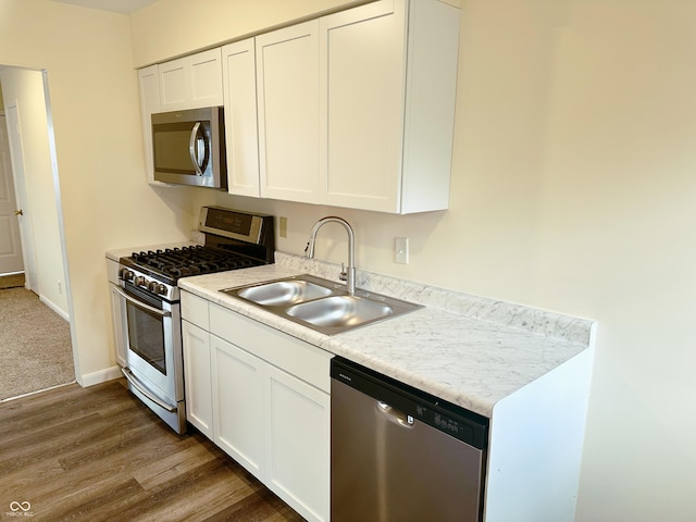 kitchen with white cabinets, sink, appliances with stainless steel finishes, and dark wood-type flooring