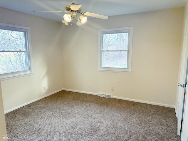 carpeted spare room featuring ceiling fan