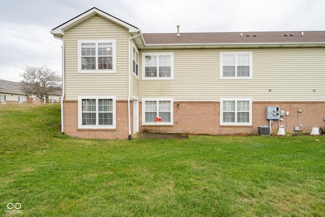 rear view of house with a yard and central AC unit