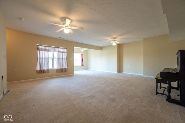 carpeted living room featuring ceiling fan and a textured ceiling