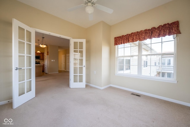 carpeted empty room featuring lofted ceiling, ceiling fan, and french doors