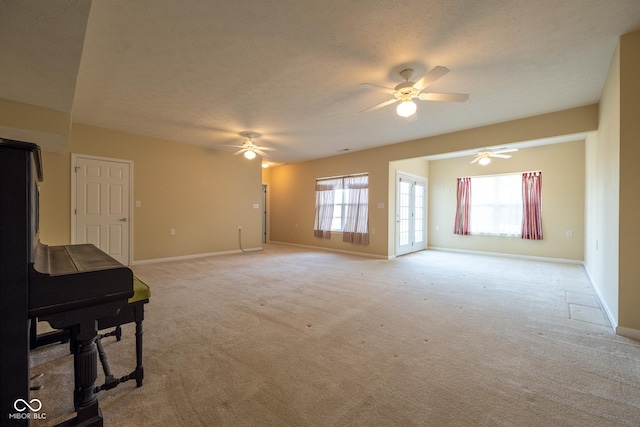 carpeted living room featuring a healthy amount of sunlight, a wood stove, a textured ceiling, and ceiling fan