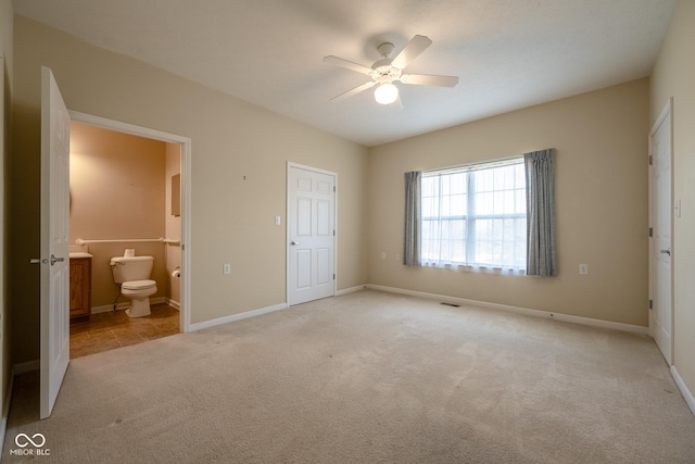 unfurnished bedroom with light carpet, ensuite bath, and ceiling fan