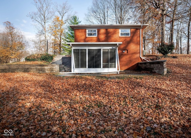 rear view of property featuring a sunroom