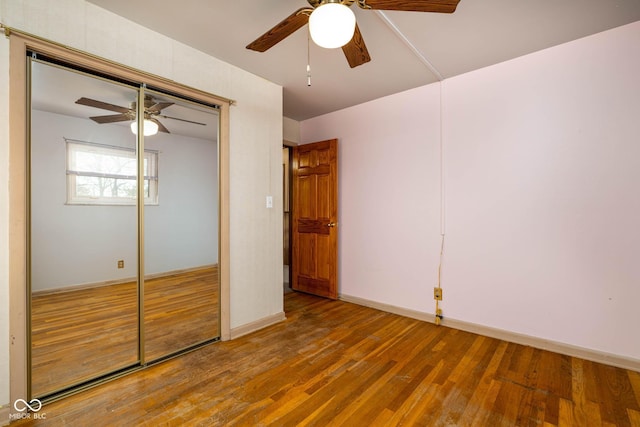 unfurnished bedroom featuring hardwood / wood-style floors, ceiling fan, and a closet