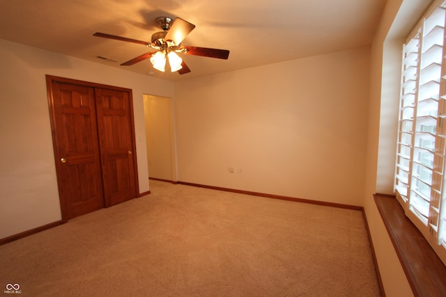 unfurnished bedroom featuring carpet, a closet, and ceiling fan