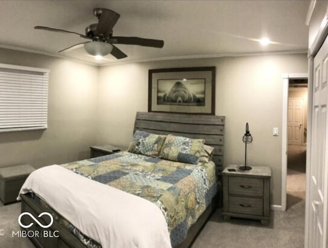 carpeted bedroom with ceiling fan and ornamental molding