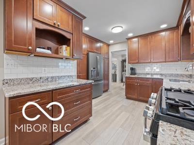 kitchen with light stone counters, sink, stainless steel appliances, and light hardwood / wood-style floors