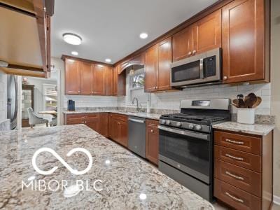 kitchen with backsplash, light stone counters, and stainless steel appliances