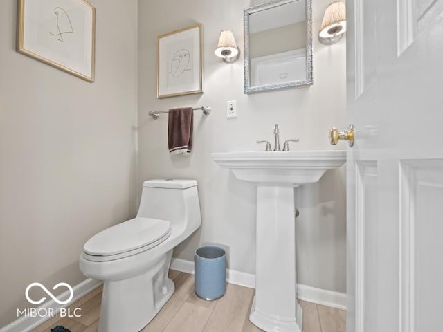 bathroom with hardwood / wood-style flooring and toilet