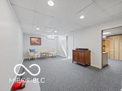 living area with carpet flooring and a drop ceiling