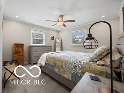 carpeted bedroom with ceiling fan and crown molding