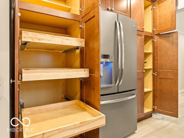 kitchen with stainless steel fridge and light hardwood / wood-style flooring