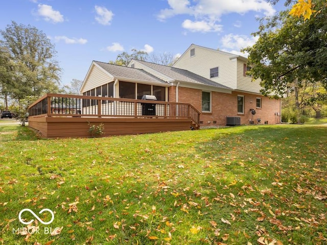 rear view of property featuring a sunroom, central AC unit, a deck, and a lawn