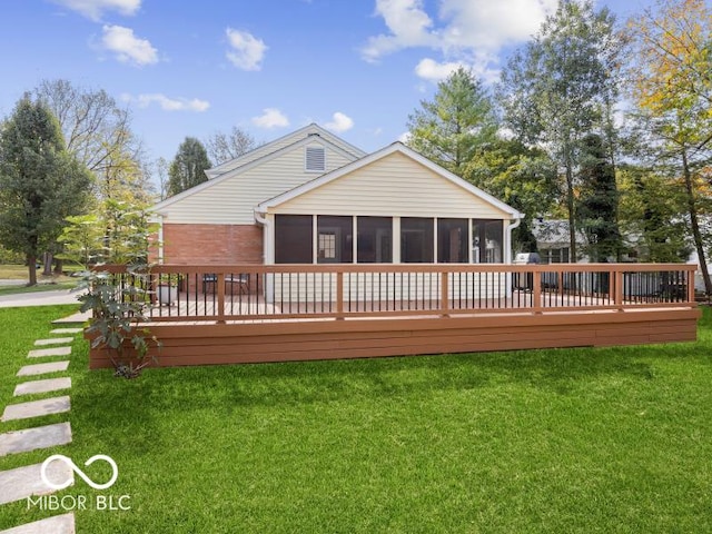 back of property with a lawn, a sunroom, and a deck