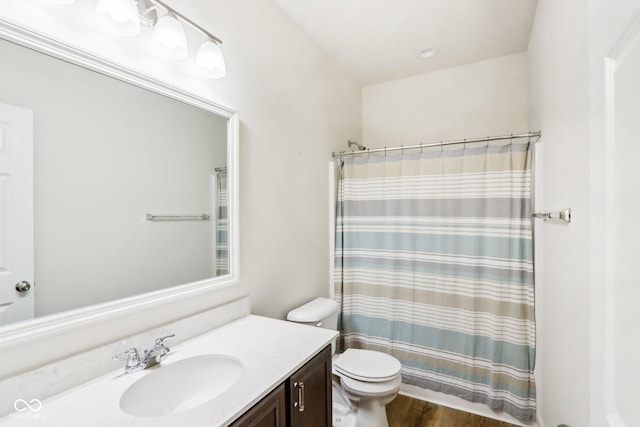 bathroom featuring a shower with curtain, vanity, hardwood / wood-style flooring, and toilet