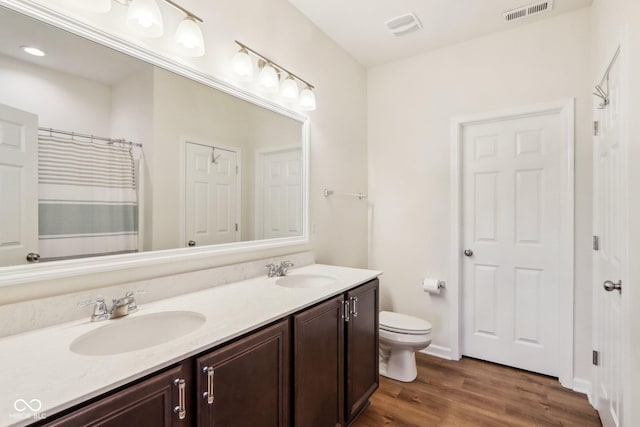 bathroom with toilet, vanity, a shower with shower curtain, and hardwood / wood-style flooring