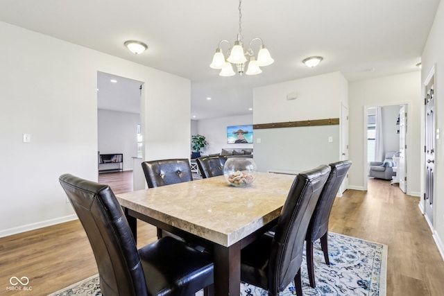 dining room featuring wood-type flooring and a notable chandelier