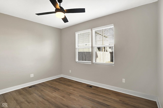 unfurnished room featuring a ceiling fan, dark wood finished floors, visible vents, and baseboards