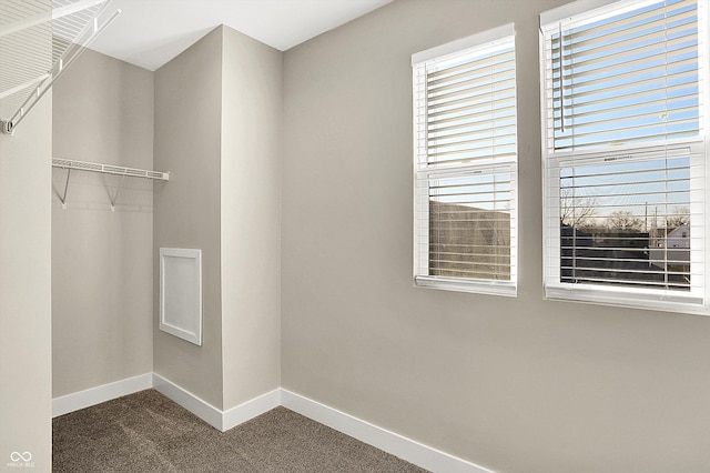 spacious closet with dark colored carpet