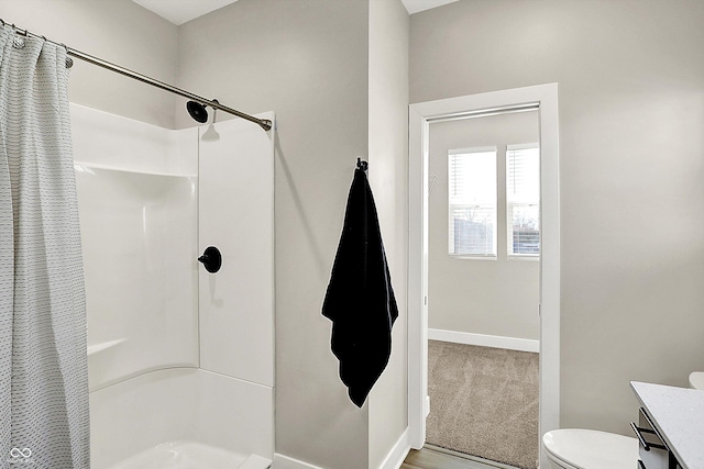 bathroom with toilet, vanity, baseboards, and a shower with shower curtain